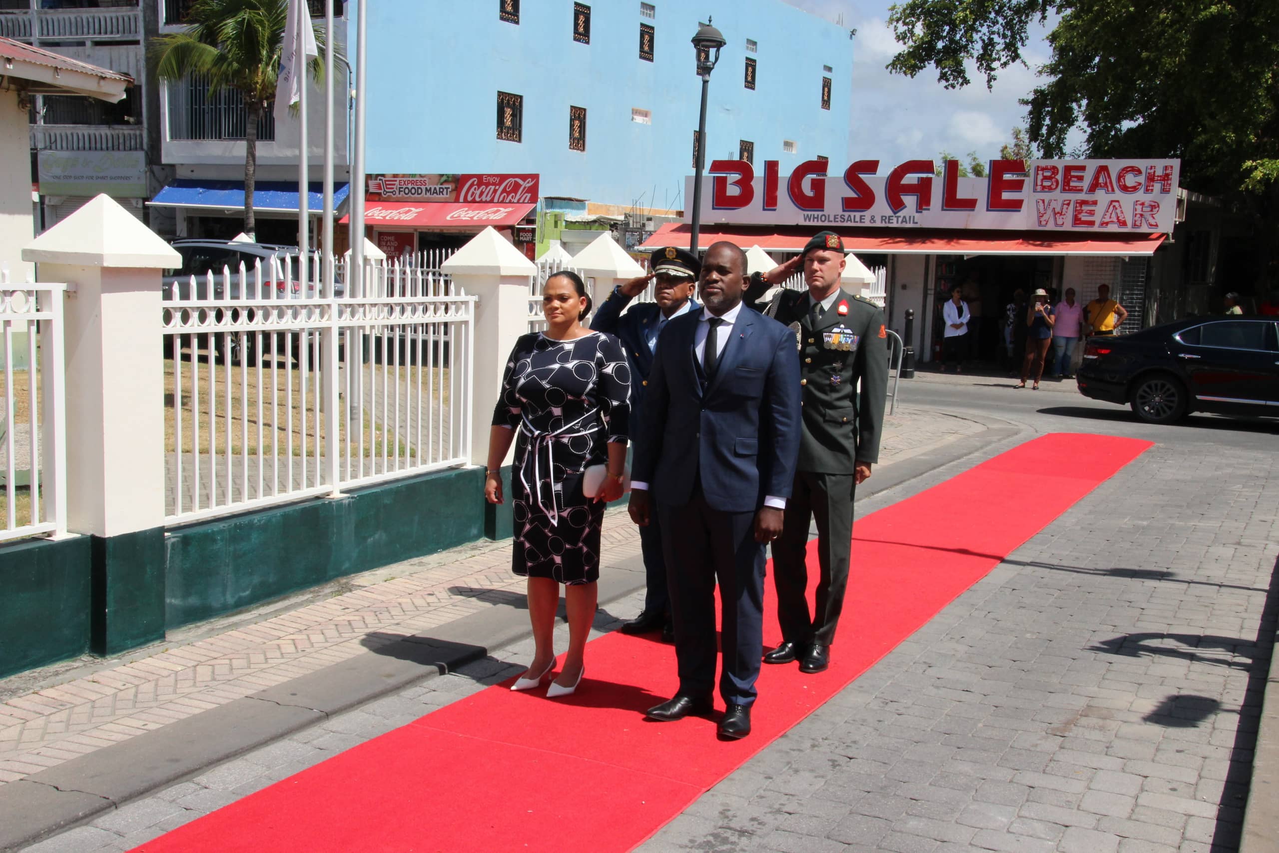 De Gouverneur van Sint Maarten en zijn echtgenote worden protocollair ontvangen op de rode loper bij het Parlementsgebouw.